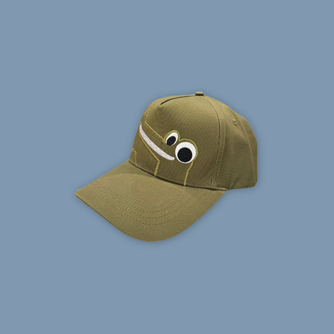 Green cap with cartoon face design on a blue background Mandai Wildlife Reserve